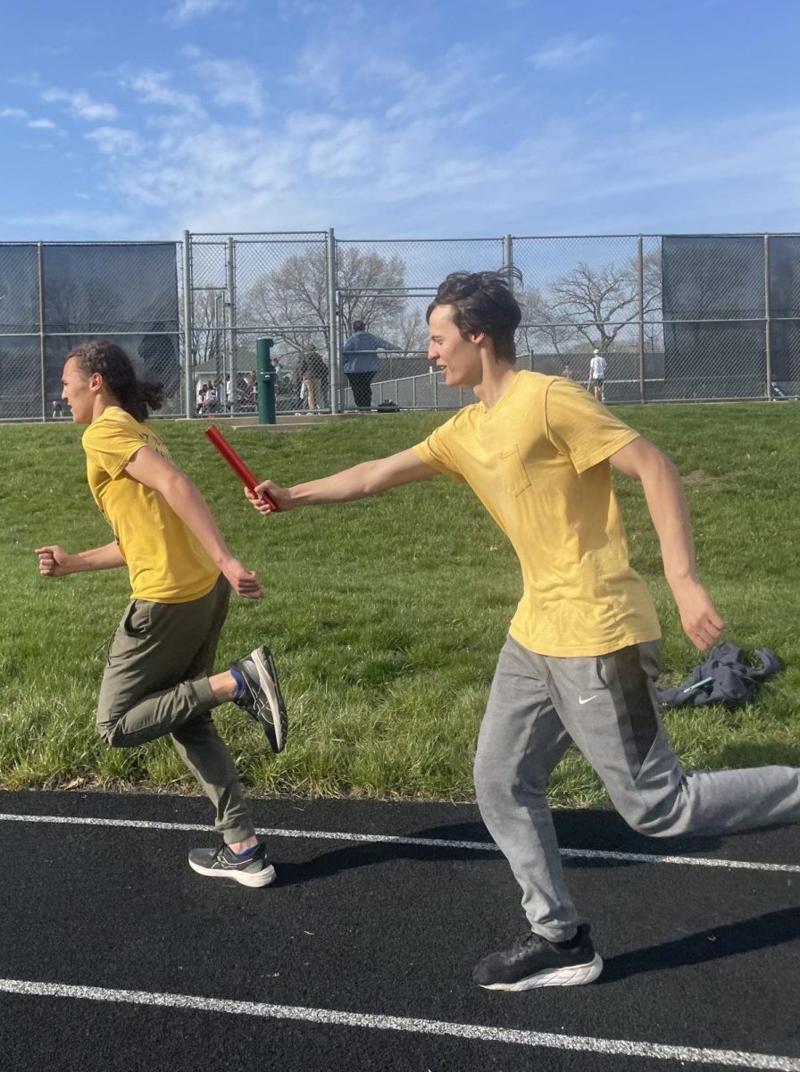 PRACTICE PARTNERS. Oliver Thompson passes the baton to his younger brother Langston at a track practice. The siblings have been on the track and basketball teams together. I give him more direction than other people, Oliver said.