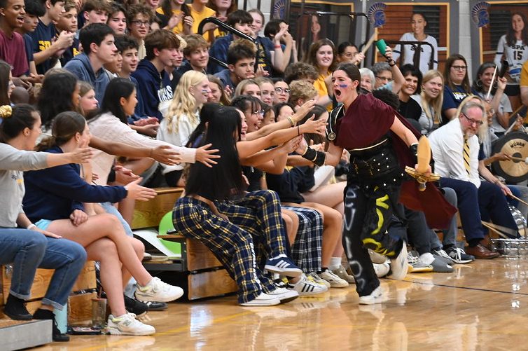 SPARTAN SPIRIT. Spartan mascot Cassandra Overholt high fives students after defeating the BSM Crusader in a pre-game skit.