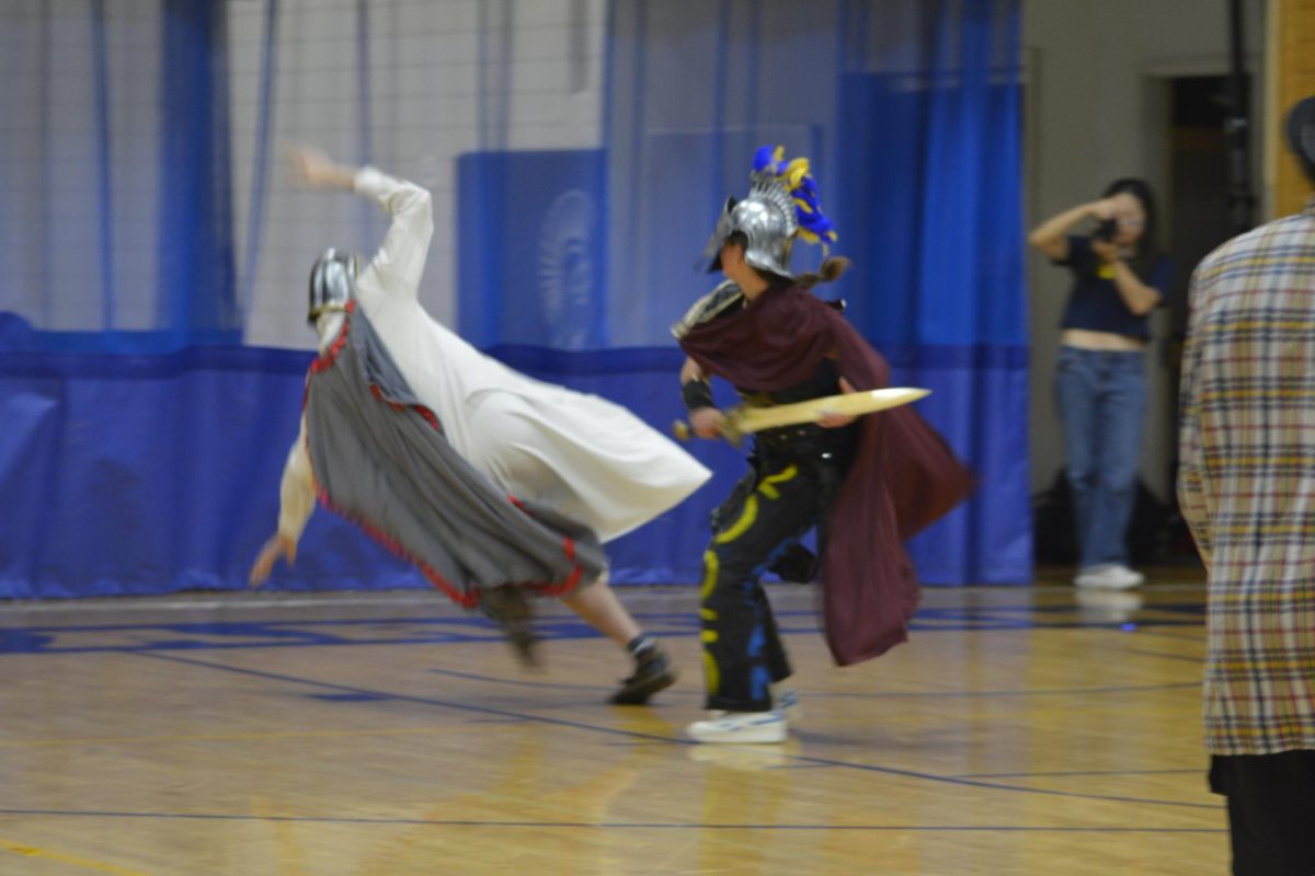 SLAIN. One of this year's two Spartan mascots, senior Cassandra Overholt defeats the BSM Crusader, senior Adam Ebert, in a skit at the end of Pepfest. Shortly after, the Spartans and Crusaders faced off in the homecoming soccer game.