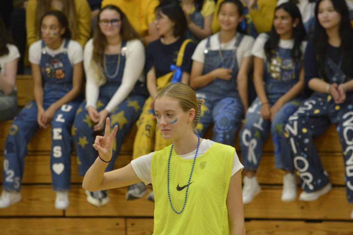 REFEREE. Sophomore Tallulah Dogwill holds up two fingers, signifying two points for the teachers.