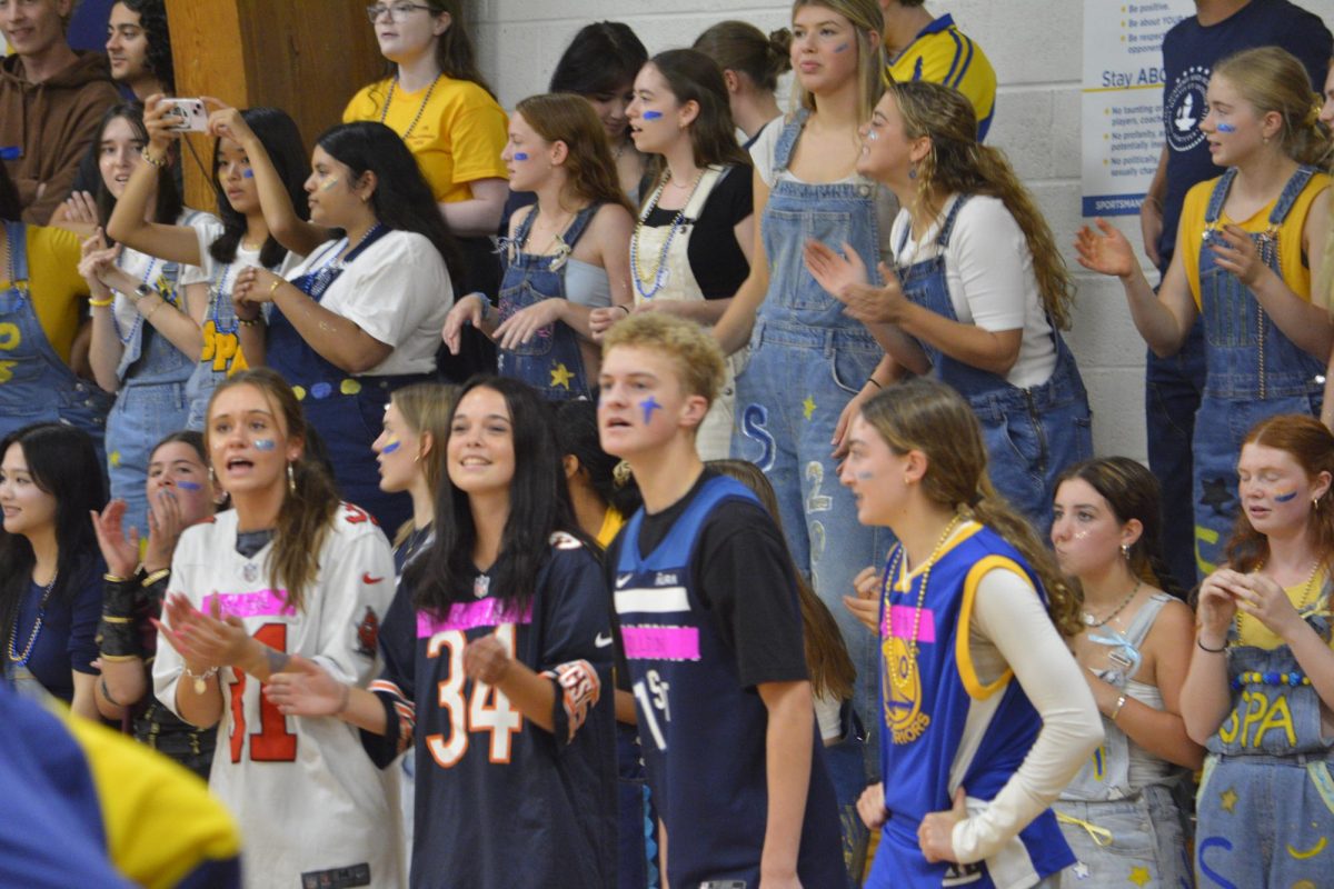 ADVICE FROM THE SIDELINES. The outed members of Roll Tide shout their encouragements. Behind them, seniors on the bleachers cheer on Ballsagna.