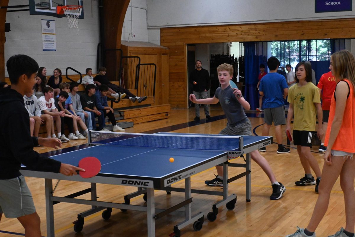 STRETCH OUT. Freshman Winston Arvidson reaches out to hit a forehand after his opponent, freshman Liam Burns, angles a shot to the corner of the table. Participants competed in the ping pong tournament on Monday and finalists face off during the Pep Fest on Friday.