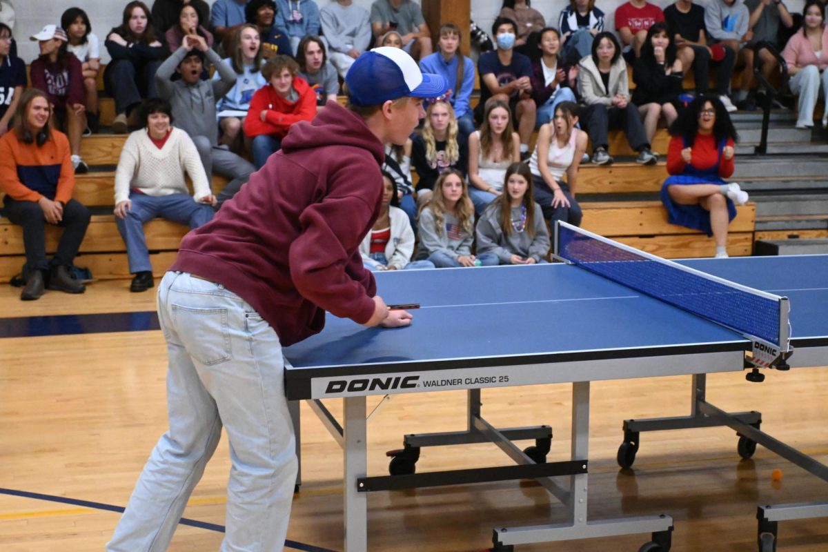 REACH. Senior Andrew Evans stretches his ping pong paddle towards the net, attempting to return a short ball.