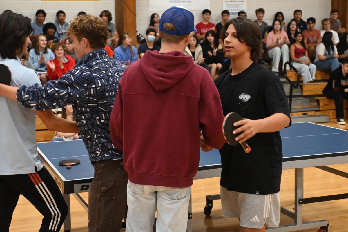 GOOD MATCH. Sophomore Isaak Senaratna, senior Andrew Evans, senior David Schumacher, and senior Jacob Colton shake hands after their match.