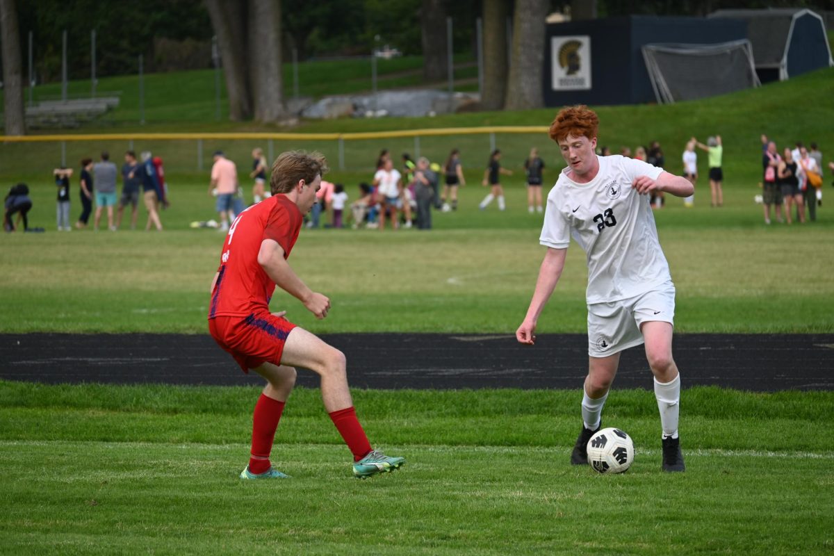 DODGE. Senior August Gaspard attempts to outmaneuver opposing Scots player.