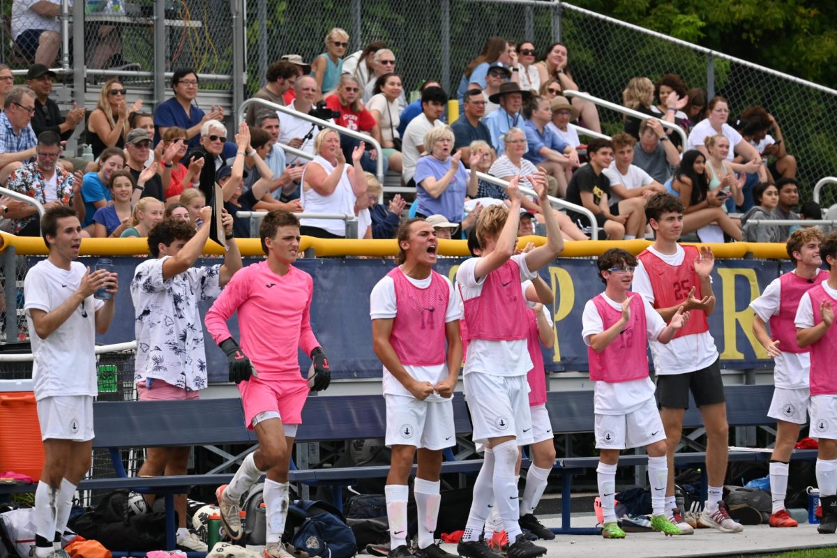 CHEER. Benched players and Spartan audience members roar in celebration of a goal.