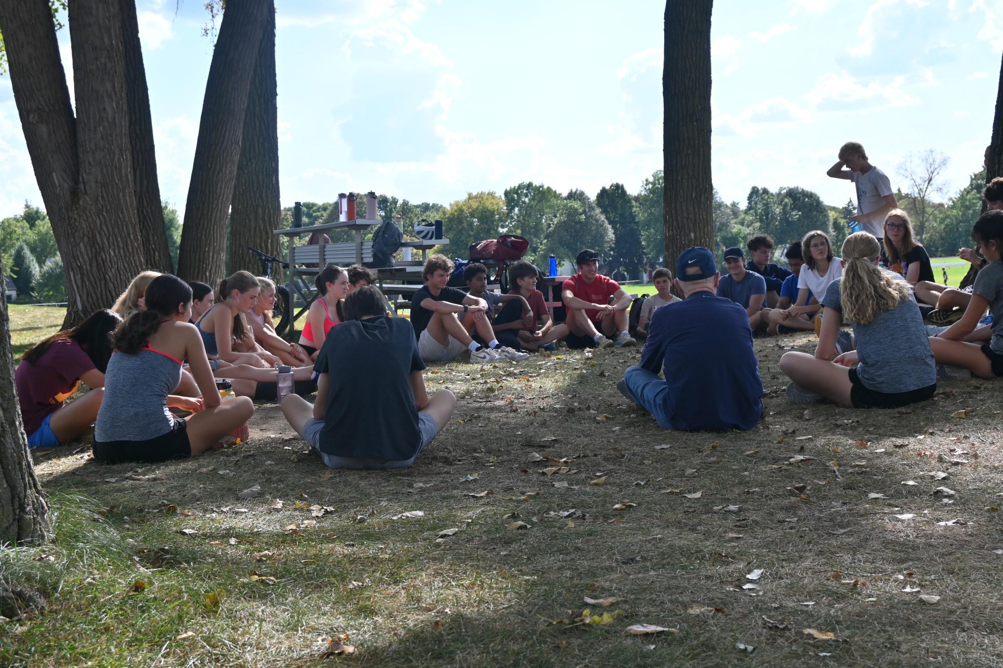 CAMRADERIE. Both girls' and boys' cross-country teams sit in a circle while listening to the coaches. 