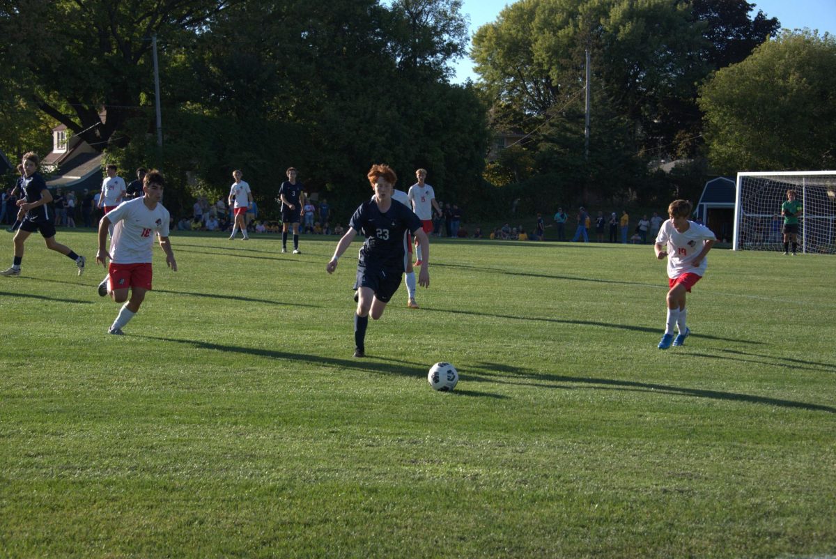 BE THERE. Senior August Gaspard races to get to the ball before two opposing players. 