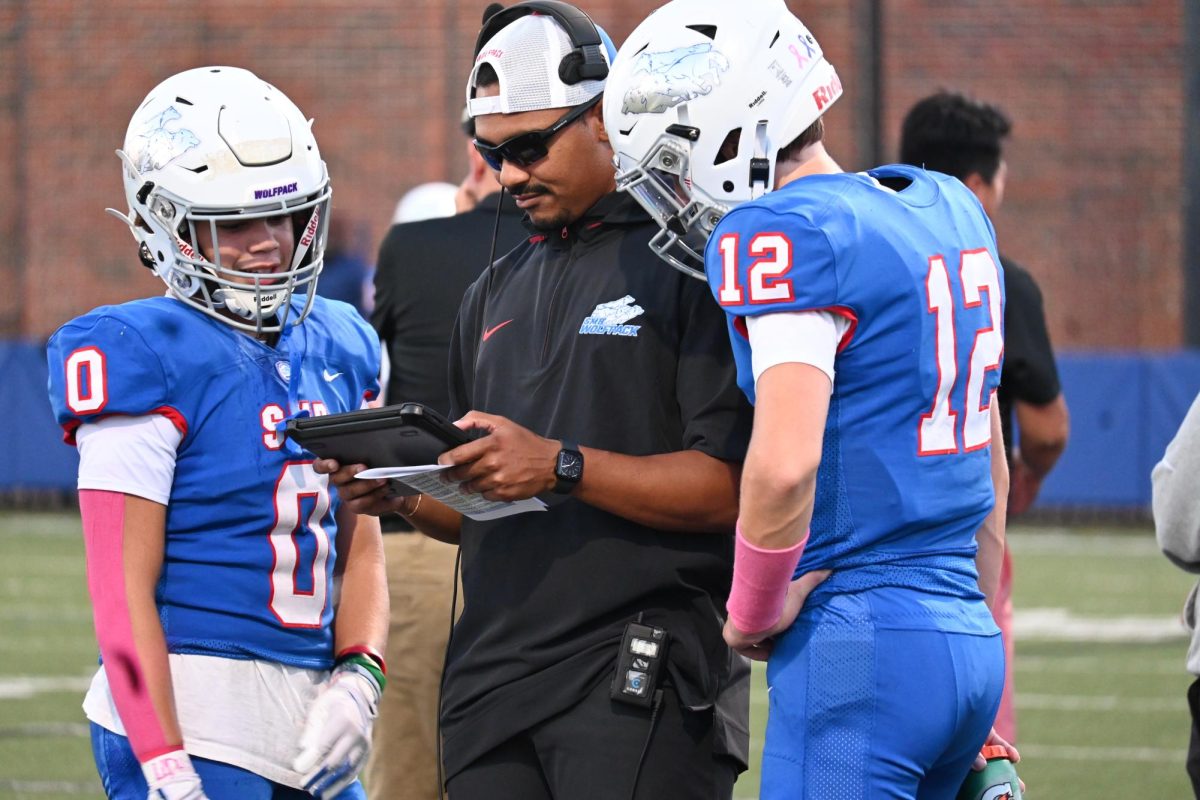 PLAY BY PLAY. Teammates go over a potential formation with their coach. 