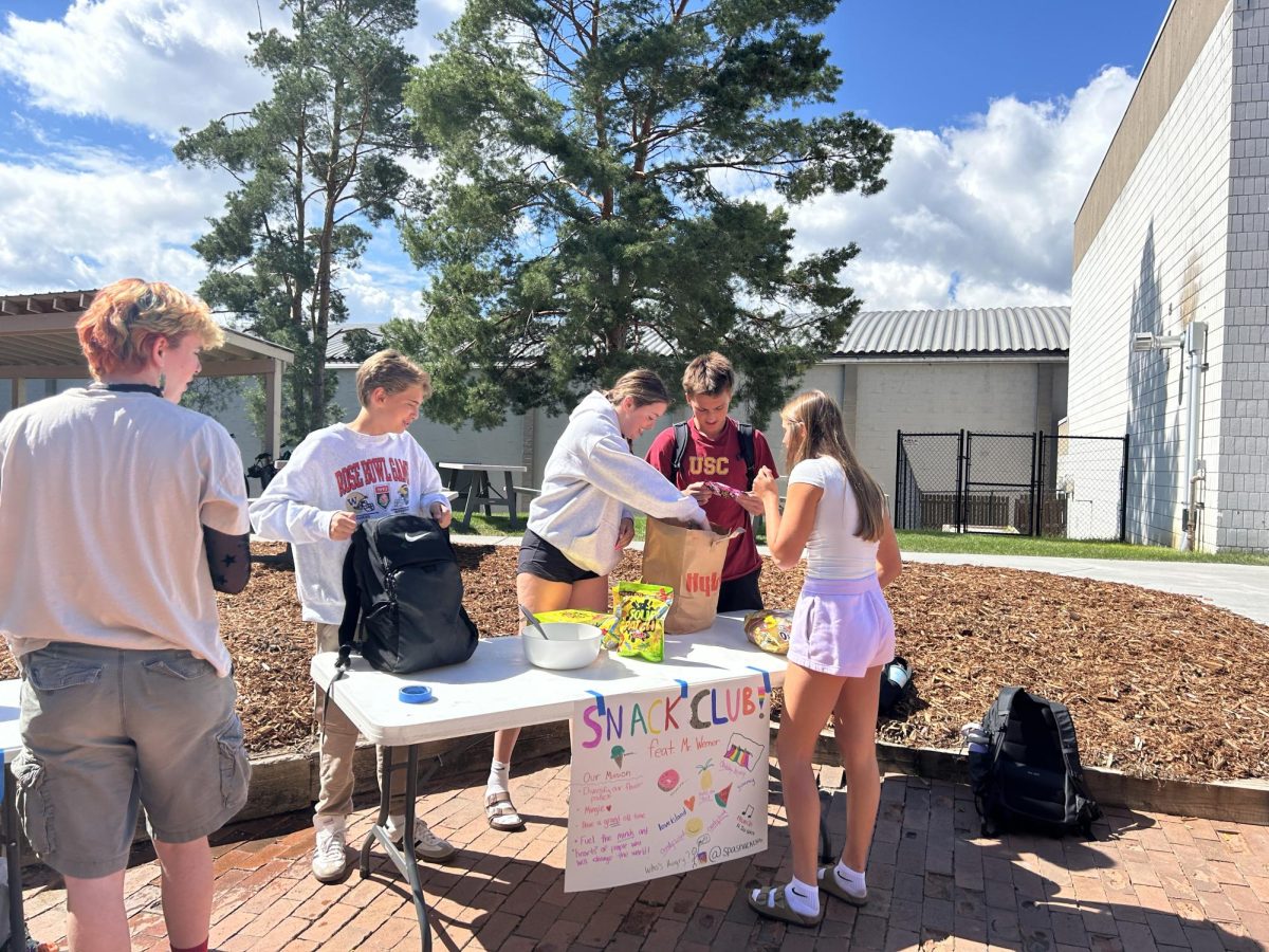 SWEET STRATEGIES. Sophomores Cormac Graupman, Murphy Miltner, Miles Vogenthaler and Audrey Peltier (‘27) plan how to place their candy out on their table for Snack Club.