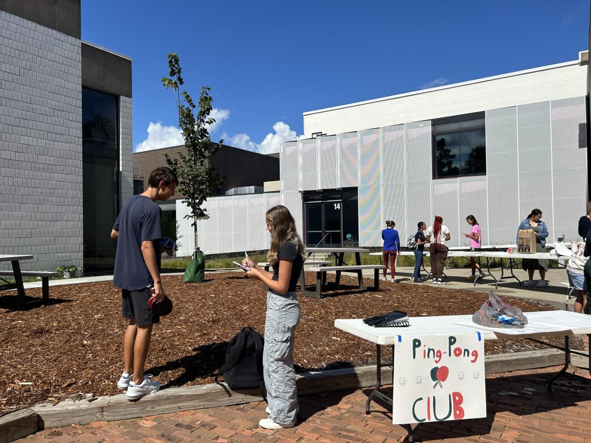 PING-PONG PREP. Junior Elle Williams plans out their ping pong set-up with her brother Aidan Williams. Ping pong takes place in the physics wing of SPA during X-period when there are clubs. 