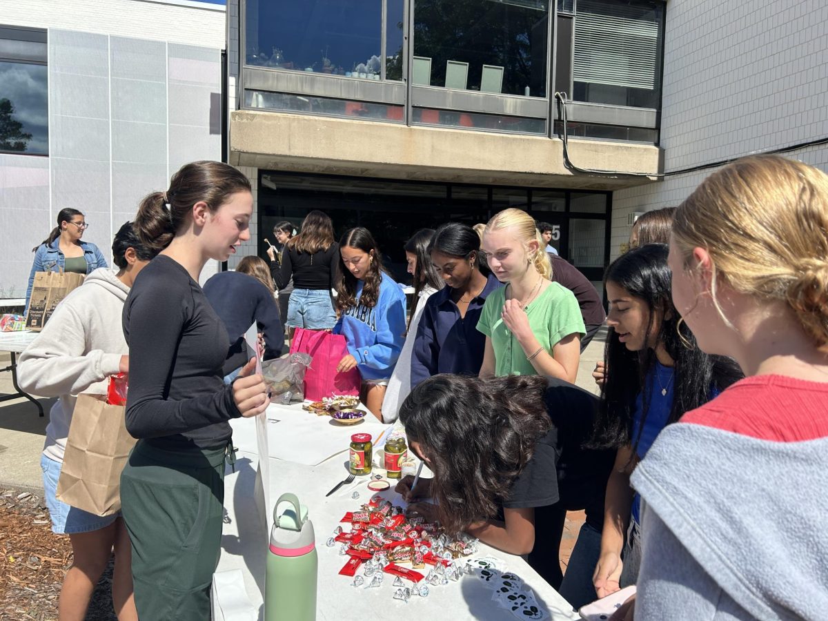 EASY EXPLANATIONS. Junior and club leader Hazel McCarthy explains pickleball club to a group of freshmen. “Pickleball club is a great way to get out energy during the school day when you’re sitting around a lot,” McCarthy notes about the club. 