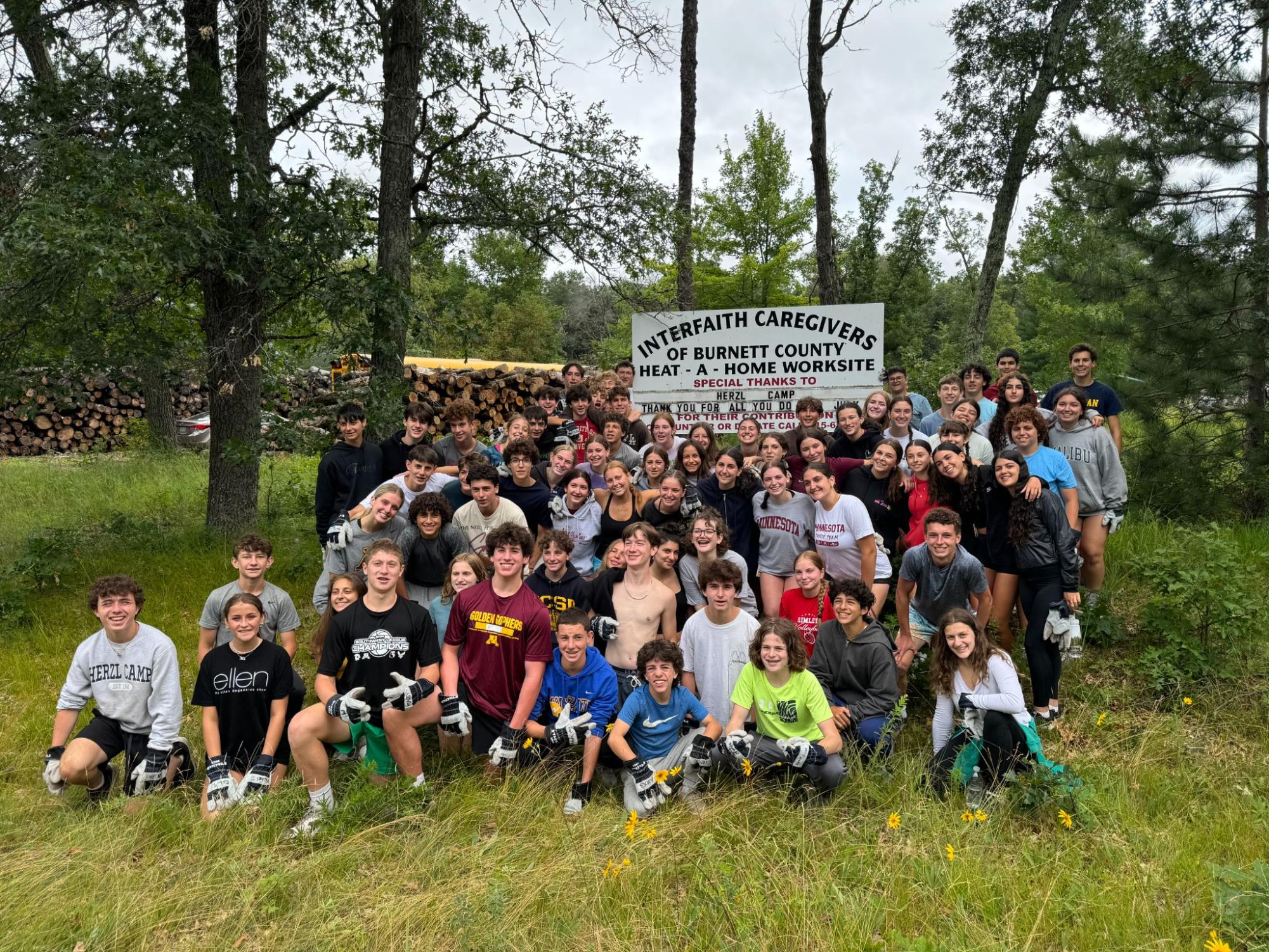 FROM WOODCUTTERS TO PLANKS. Campers of Herzl pose for the picture after participating in community service. Evie Gardner is in the middle, and Eli Sanders and Isaac Broderius are in the upper right corner; they were chopping wood for a project to build homes for people who are disabled or are having financial problems.