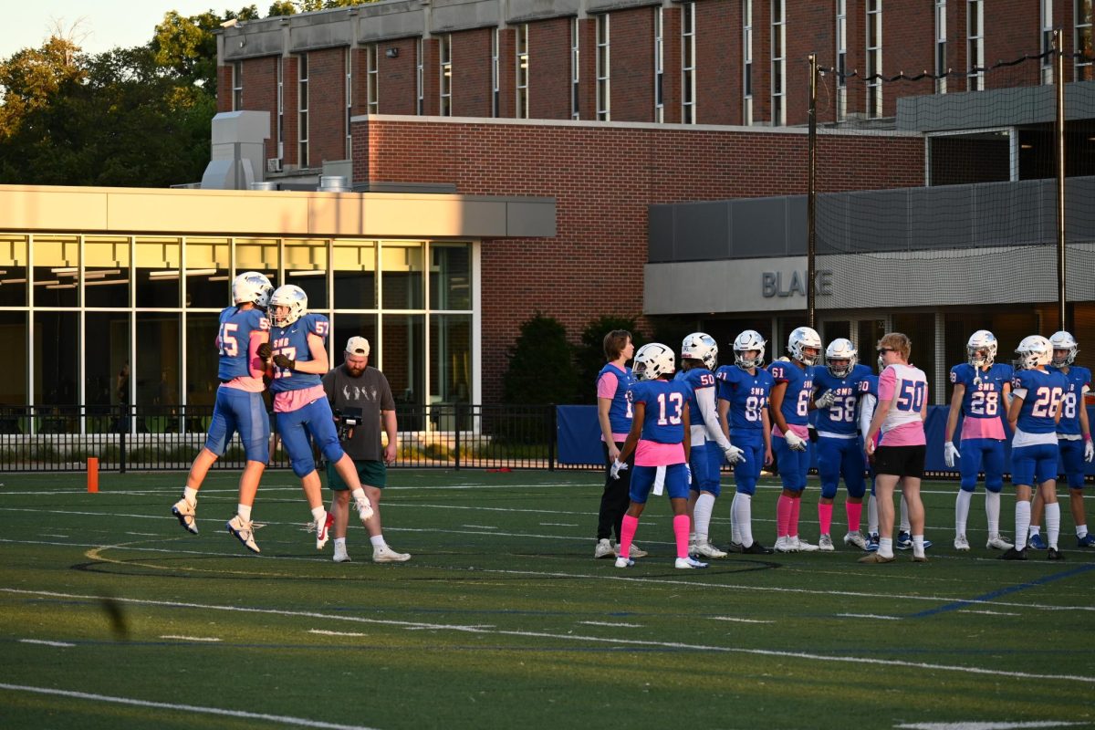 WALKOUT. Team starters jump and spin as they walkout before the game.