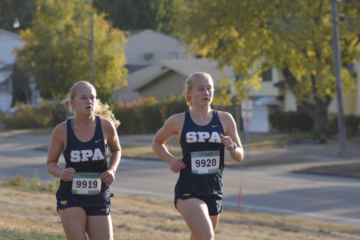 RUNNING IT TOGETHER. Freshman Alyda Overgaard (left) and junior Maren Overgaard (right) run the course right next to each other. 