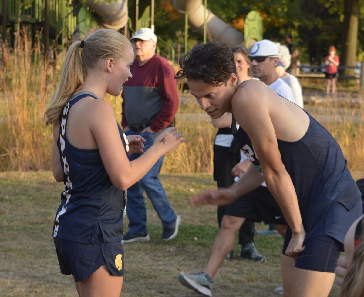 NICE JOB. Freshman Alyda Overgaard congratulates senior Oliver Thompson as he takes a breath after the race. 