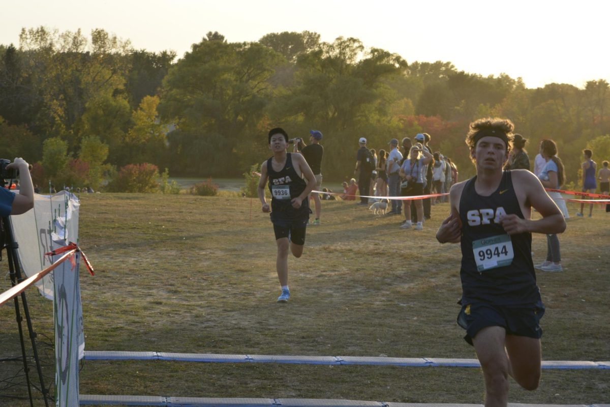 IN THE VISION. As junior Elliot Sjaastad crosses the finish-line, junior Trevor Hou follows right behind. 