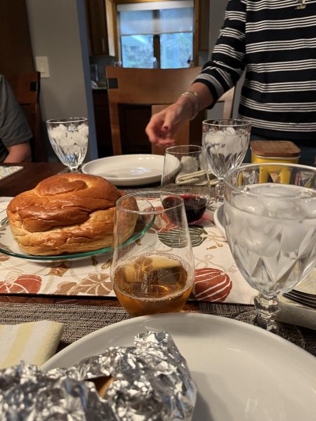 MOUTH-WATERING MEAL. Sophomore Avi Coleman has dinner with her family. A round challah can be seen on the left-hand side, and the round challah signifies that the year is coming full circle.