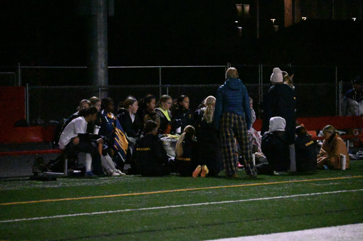 HALFTIME HOPE. GVS congregates at halftime around the team bench, discussing what went well and what is necessary to keep the lead in the second half. The temperature dropped below fifty degrees as the night went along, leading many Spartans, both players and fans to huddle under blankets on the sidelines and bleachers.