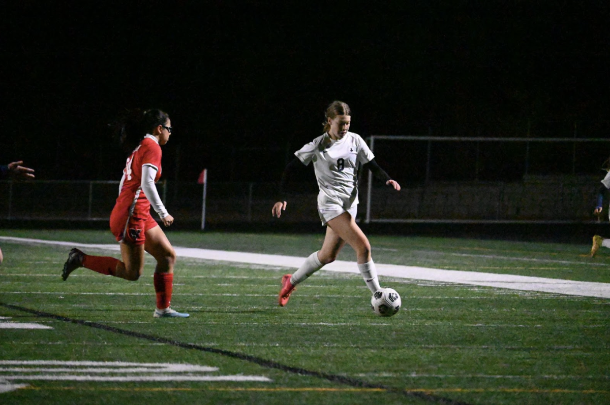 LINE DRIVE. Ninth-grader Lucy Lowman sprints down the sideline with the ball into an attacking position.