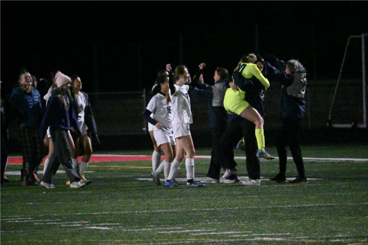 WILD WIN. Goalkeeper and senior Natalie Waibel celebrates with the coaching staff as the buzzer goes off, signaling the end of the match. As the team rushes in from the field and bench to celebrate the 1-0 win, smiles were easily seen on every Spartan face.