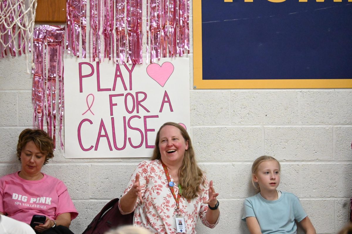 SHOWING UP. Middle school principal Virginia Andres supported the high school volleyball team, cheering through all three sets. 