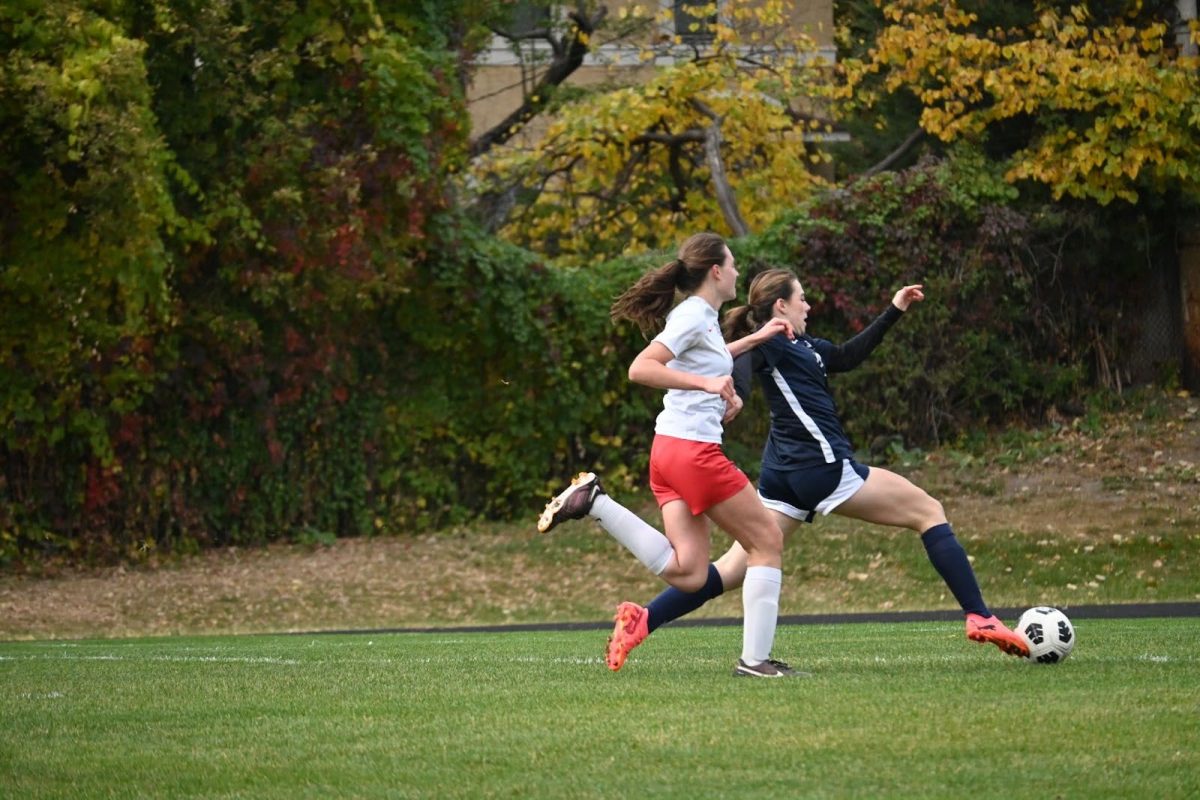 EARLY OPPORTUNITY. Clare Ryan-Bradley (‘26), the Spartans’ starting striker, lunges for a ball in an early opportunity for the team. A strategic through ball only three minutes into the game found Ryan-Bradley in space, but after a footrace with a defender, her toe-poke sent the ball just wide of the net in the first real chance of the game.