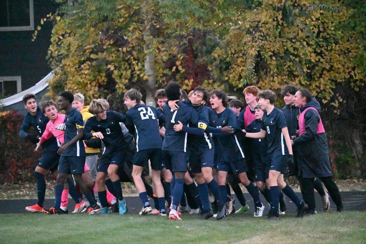 GLORY BOUND. Celebration erupts as the whole boys varsity soccer team sprints from the sideline to congratulate teammate Carson Granberg (‘25) on his beautiful finish that sends the team to the Section 3A finals. 