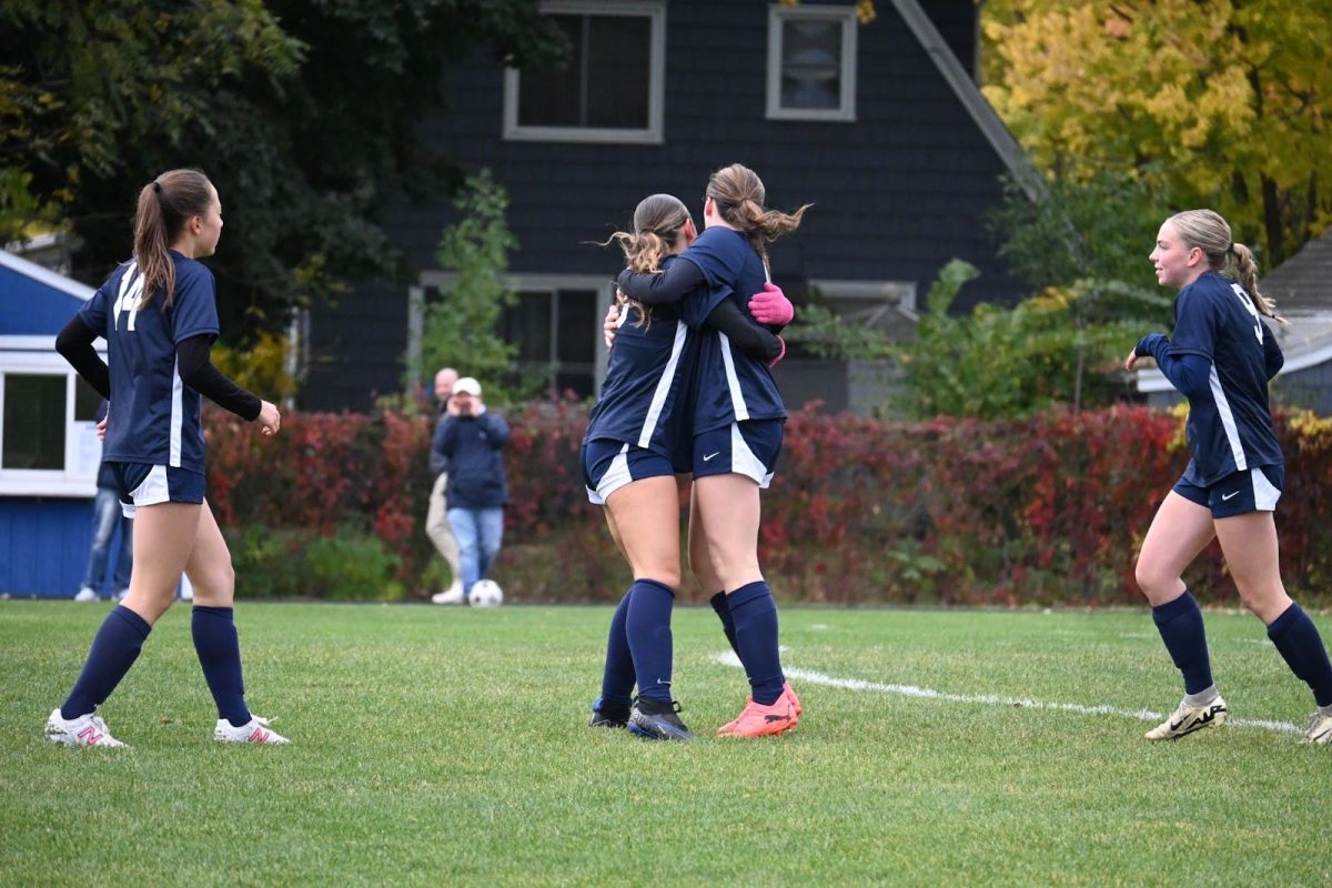 TEAM TRIUMPH. Captain Lucia Gonzales (‘26) embraces Clare Ryan-Bradley (‘26) in celebration of Ryan-Bradley’s goal as they run back to half field. 