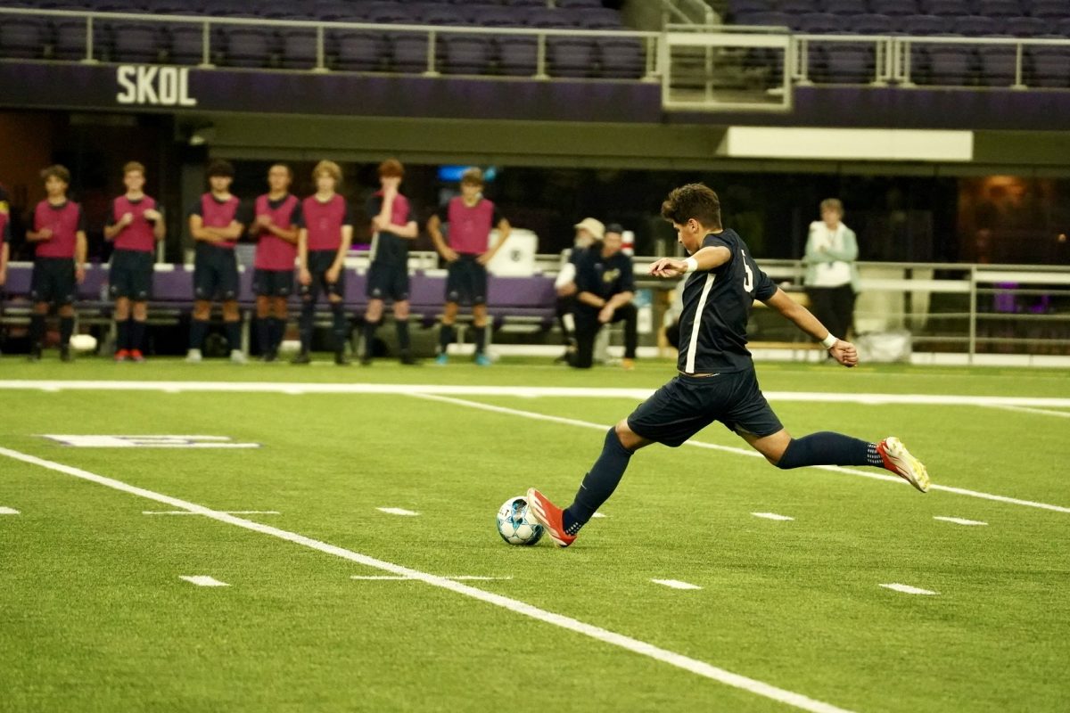 STRIKE IT. Sophomore Erik Bjorgvinsson runs fast and kicks ball in front of his teammates.