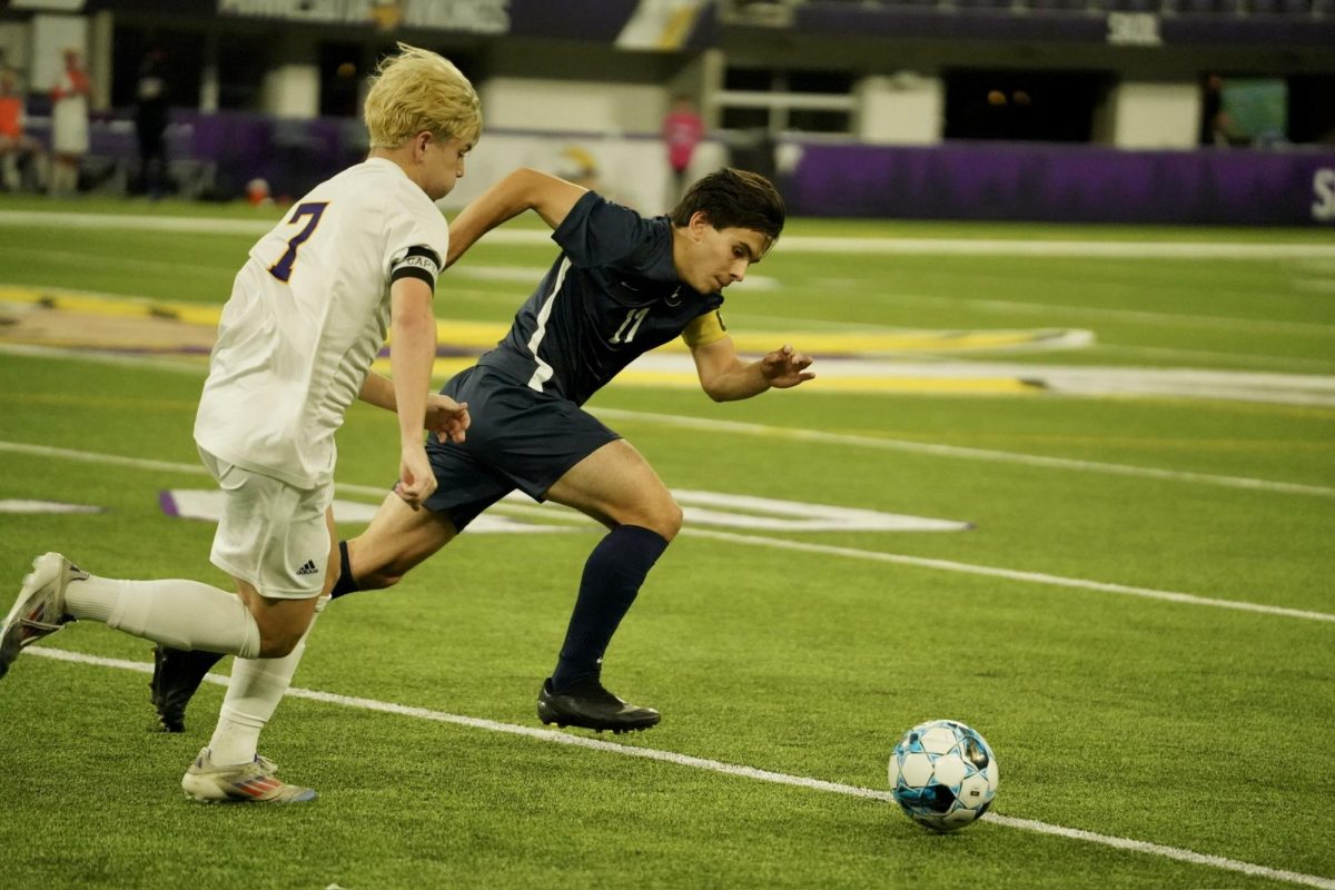 LOCKED IN. Senior Arlo Zirps sprints to beat his opponent in a race to get the ball.