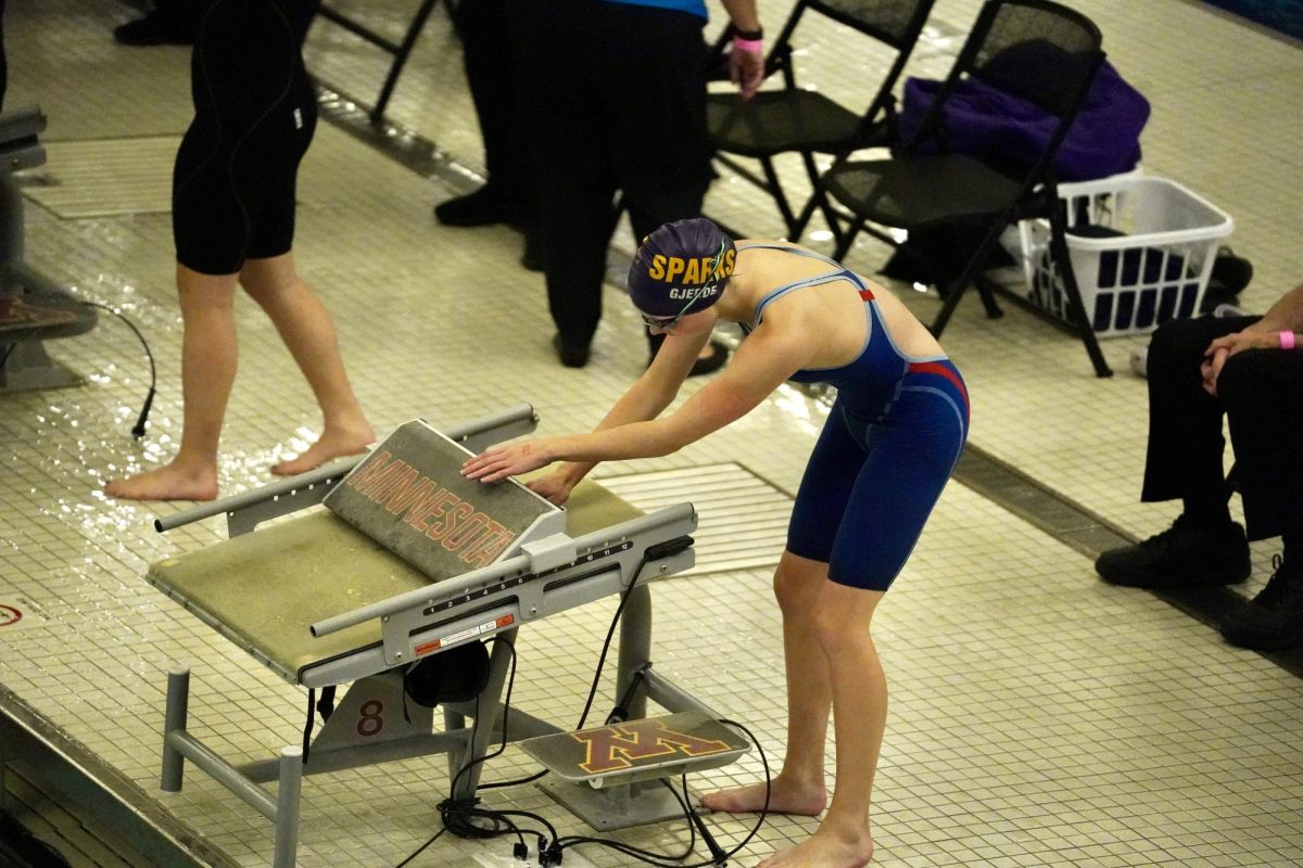 SET UP. Senior Adele Gjerde adjusts the fin on her block for her liking.