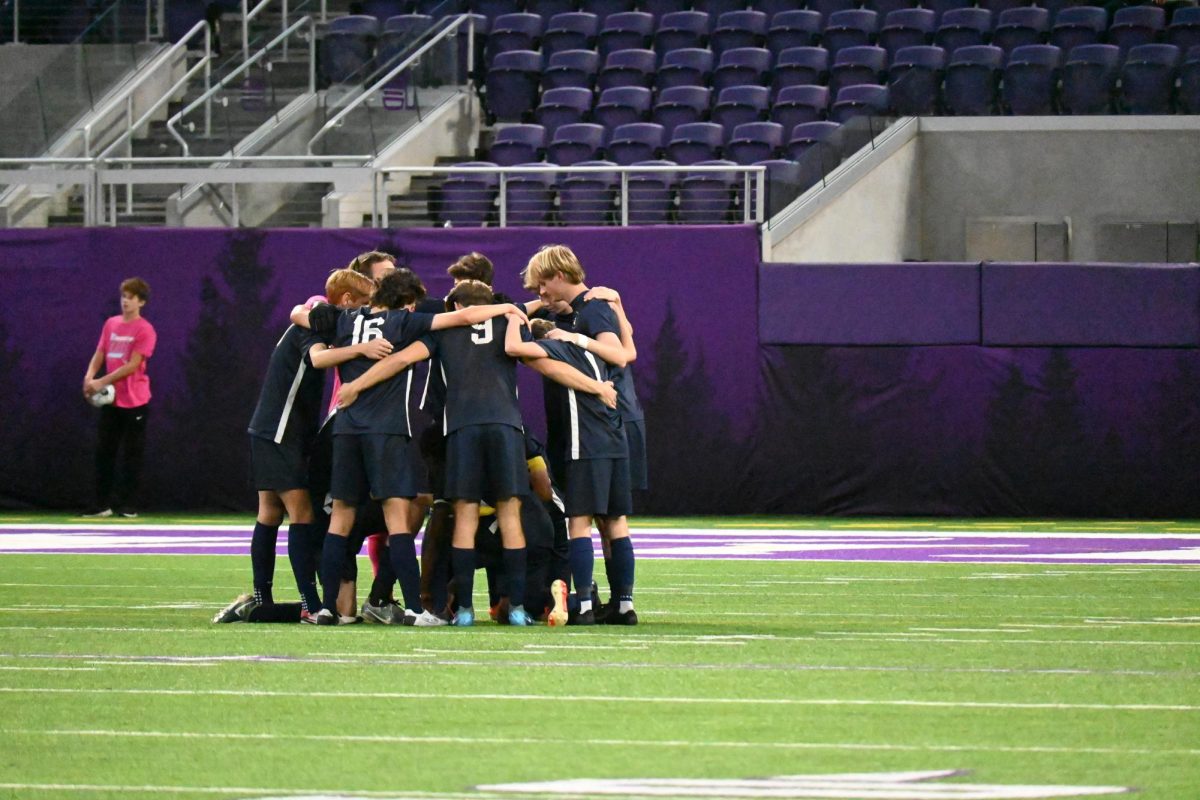 LOCKING IN. The starting eleven huddle together on the turf, discussing their plans for the game. 