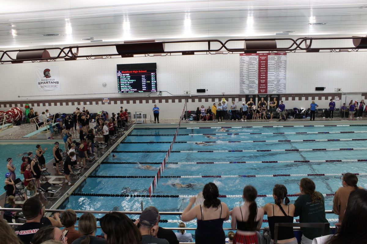 THE CROWD GOES WILD. Friends jump up as the swimmers reach the finish line. 