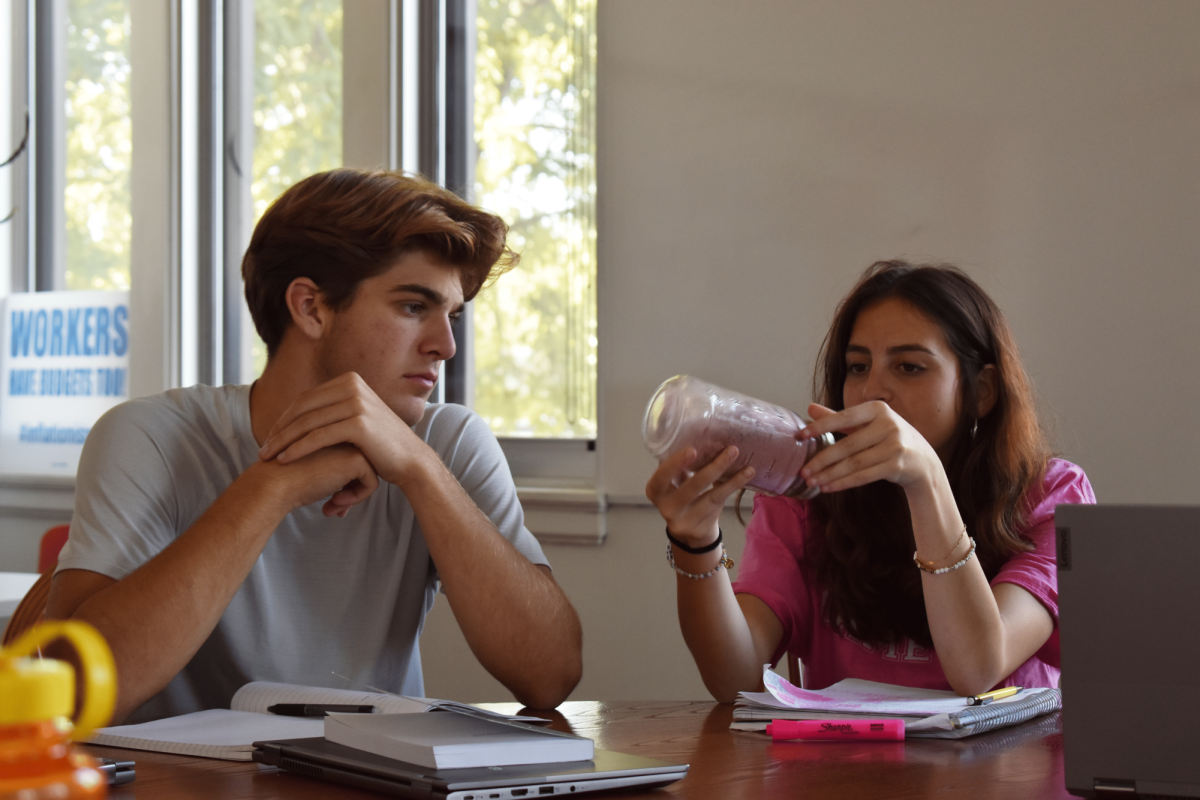 A JAR OF HISTORY. Seniors Ethan Peltier and Eva Lutgen examine a jar of crushed pipestone, central to Minnesota  Indigenous culture and history, brought in by guest speaker Lonna Stevens-Hunter.