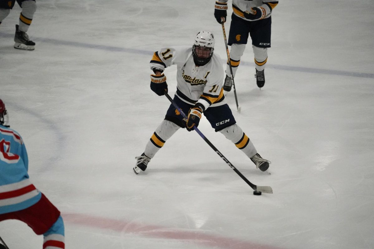 PASS THE PUCK. Forward Jimmy Steiner, a senior from Saint Agnes, passes the puck around a Simley player.