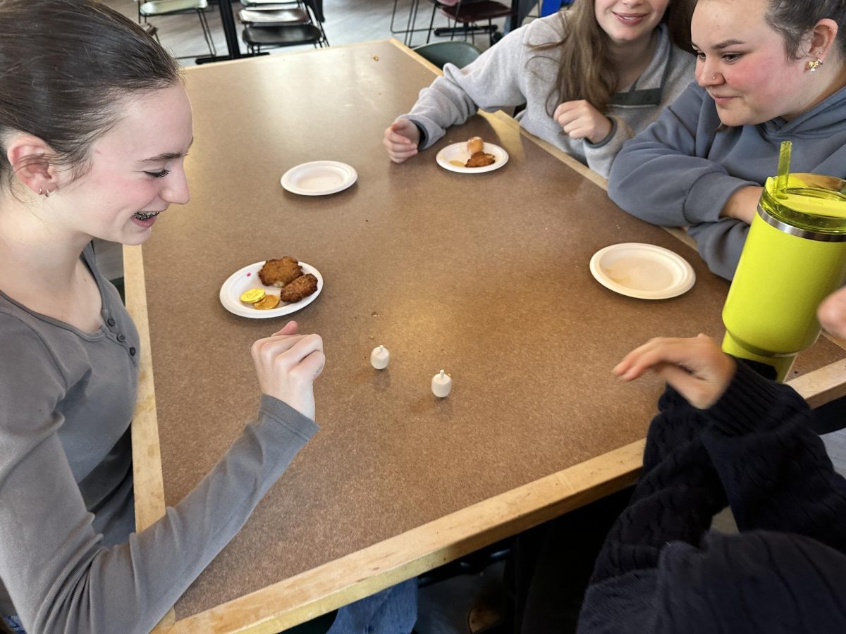 SPIN TO WIN. Junior Hazel McCarthy spins a dreidel and eats latkes to celebrate Hanukkah.