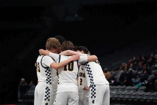 HUDDLE. The varsity starters gather together before the first whistle of the rematch. 