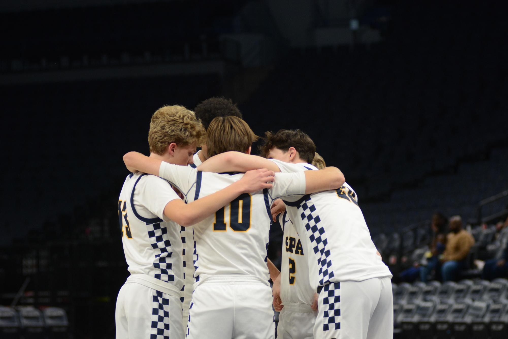 PREPARE. The starters huddle up on the court in preparation of the game. 