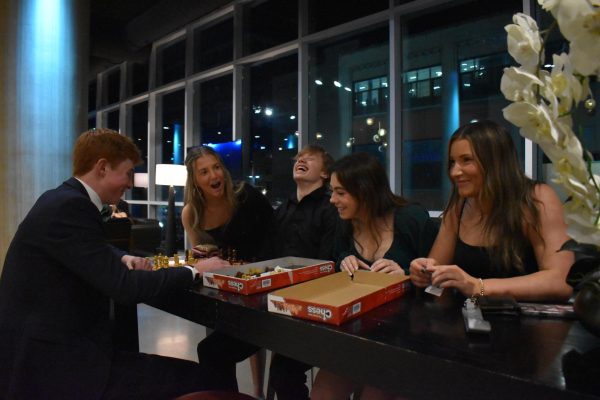 GAME TABLE. Sophomore William O'Brien cracks a joke to his friends while playing Chess and everyone laughs.